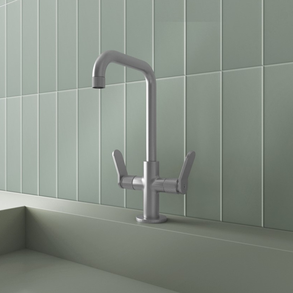 Lifestyle image of the Crosswater Calix Brushed Stainless Steel Tall Basin Mixer installed atop a green basin